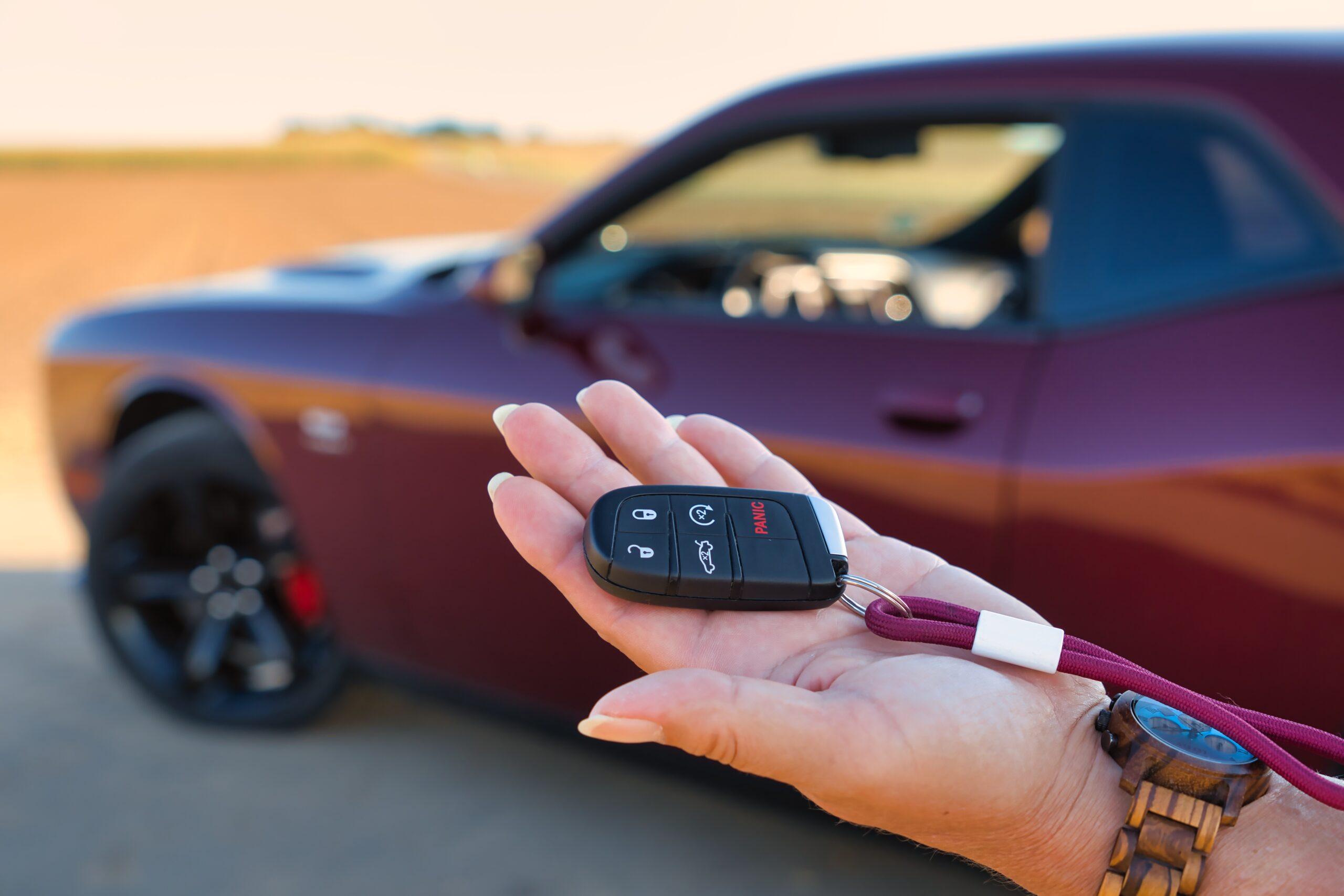 車のスマートキーを手に持つシーン