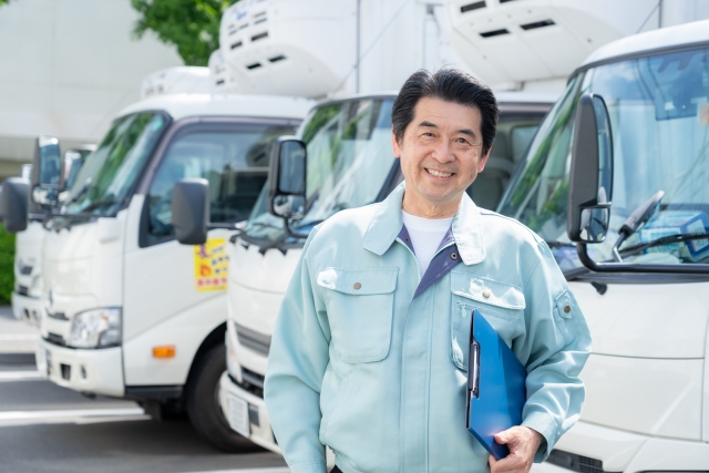 書類を手にする作業着姿の男性